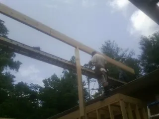 Carpenter setting a ridge beam over a new addition frame — Ice Dam Removal by Roofing Brothers in Bodega Bay