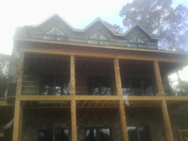 Dormers and porch framing on a large log home under construction — Roof Coating work by our crew in Bodega Bay