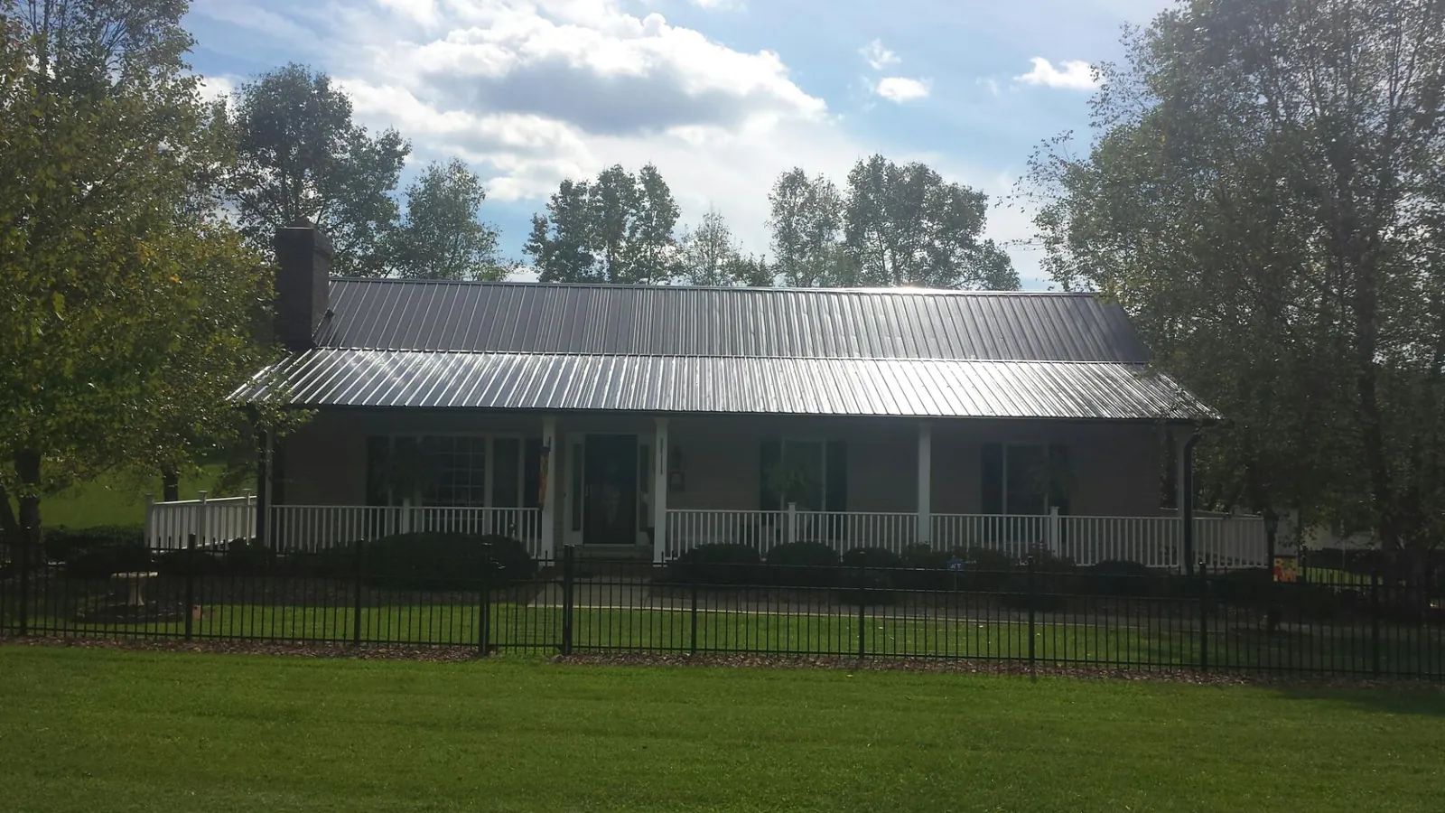 Gray metal roof on a brick ranch with a full width front porch — Gutter Guard Installation work by our crew in Bodega Bay